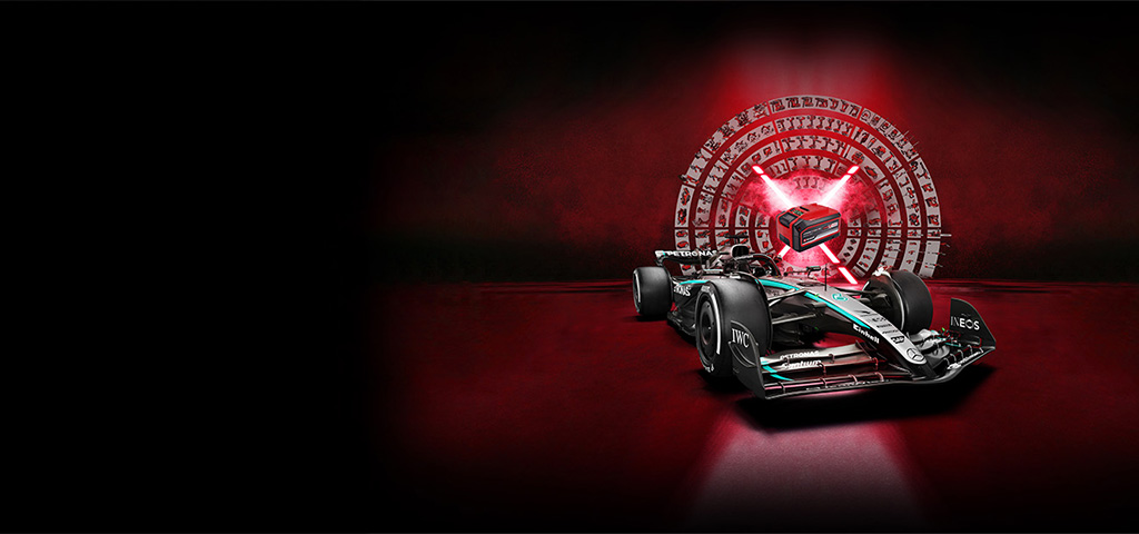 Un carro de Fórmula 1 de carreras se encuentra en primer plano sobre un fondo rojo oscuro. Al fondo, una batería estilizada Power X-Change brillante está rodeada por un círculo de herramientas e íconos de Einhell, simbolizando potencia, tecnología y versatilidad.